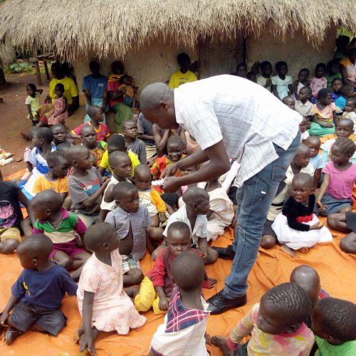 JDI Staff giving deworming tablets to children in Olyeko-ambe community after examining them.