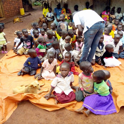 JDI staff giving deworming tablets to children in Olyeko-ambe, Papoga Parish after examining them.